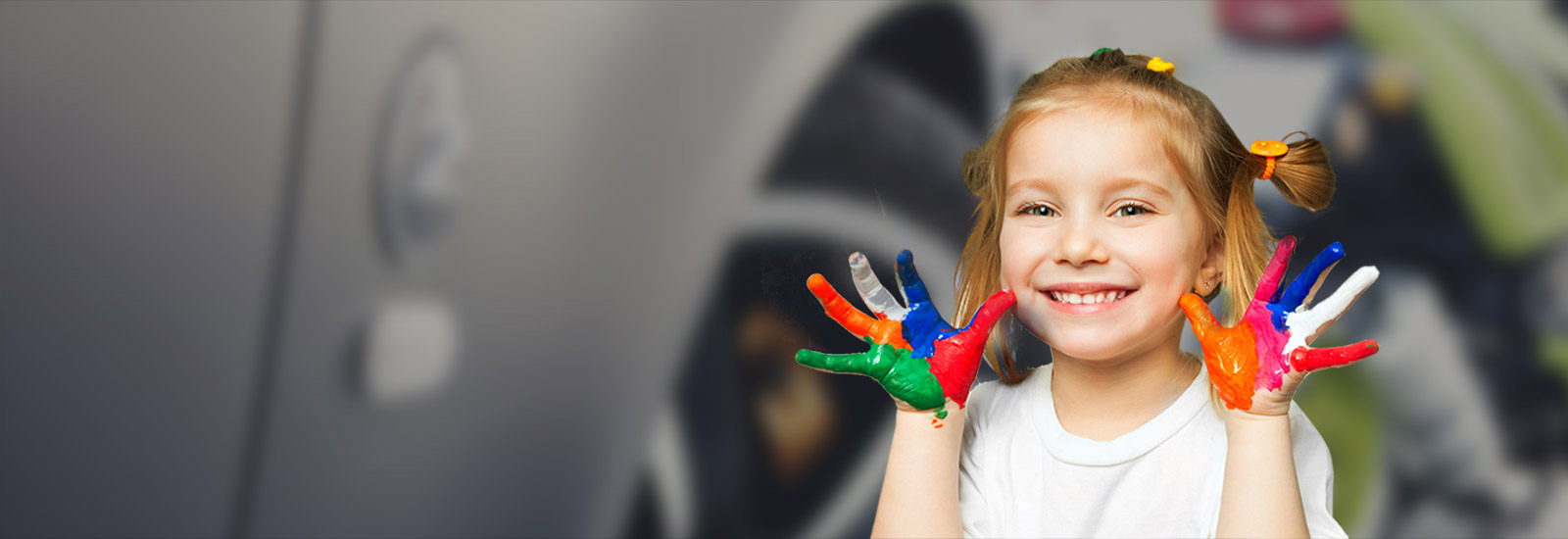 fille qui sourit en montrant ses mains pleines de peinture